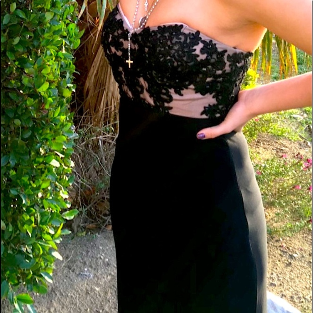 Formal black dress, lace on the chest, and a slit
